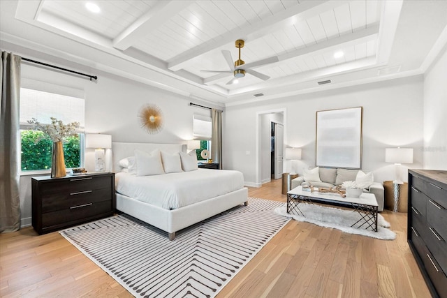 bedroom featuring light wood finished floors, beam ceiling, baseboards, and visible vents