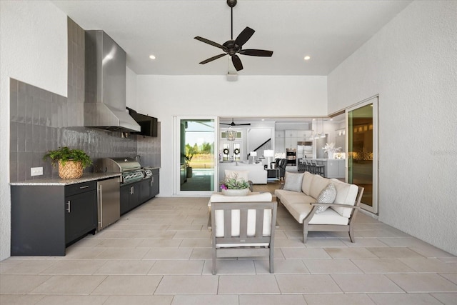 living area featuring light tile patterned floors, recessed lighting, a ceiling fan, and a textured wall