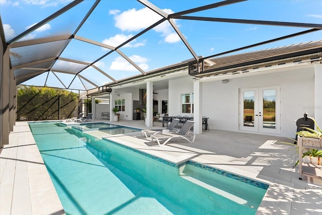 view of pool with a patio, french doors, a pool with connected hot tub, and a lanai