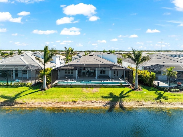 rear view of house with glass enclosure, an outdoor pool, a yard, and a water view