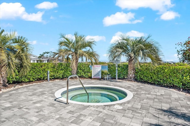 view of swimming pool with a hot tub