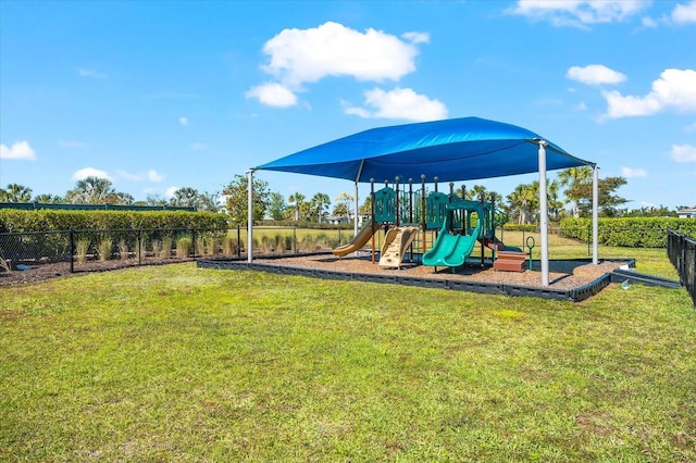 community jungle gym featuring a yard and fence