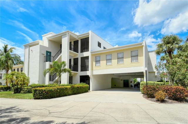 view of property featuring a carport and concrete driveway