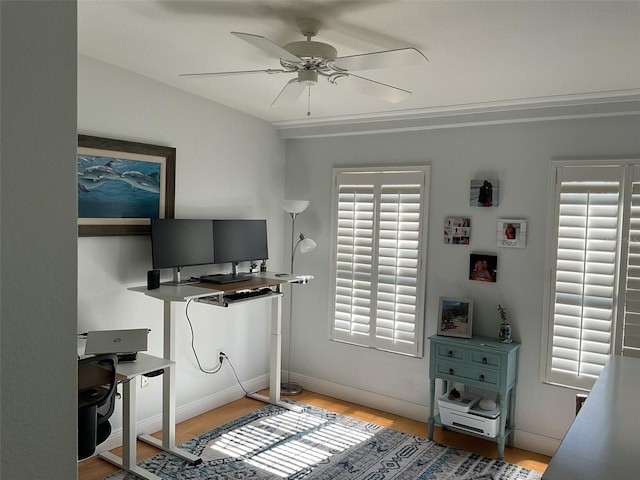 office area with baseboards, light wood-type flooring, and ceiling fan