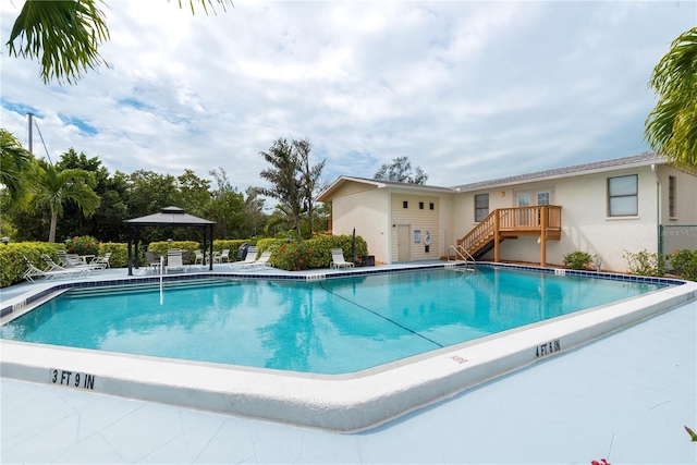 community pool with a gazebo, a patio area, and stairs