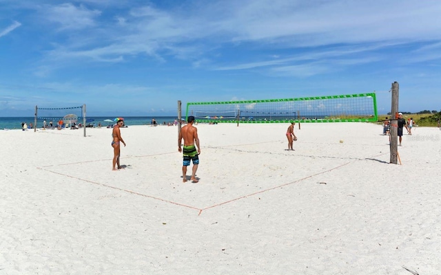 view of property's community featuring a view of the beach, volleyball court, and a water view