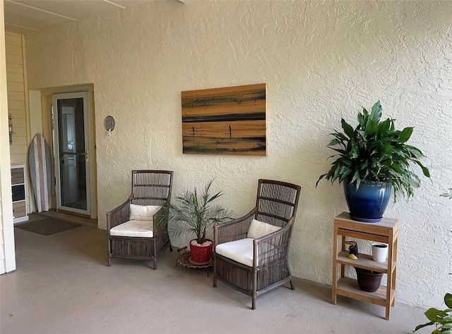 sitting room with carpet and a textured wall