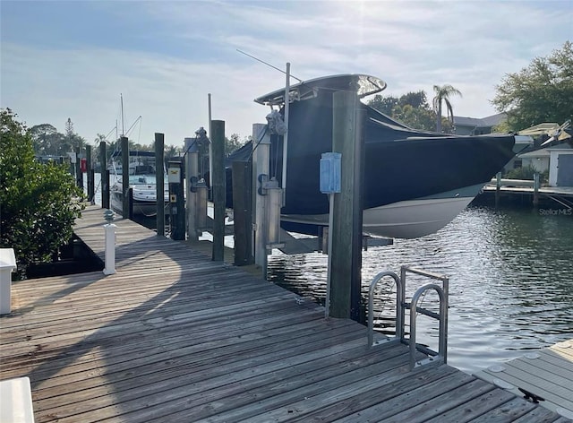 dock area featuring boat lift and a water view