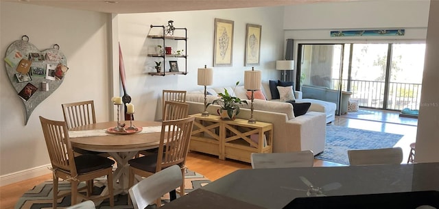 dining space featuring light wood-style flooring and baseboards