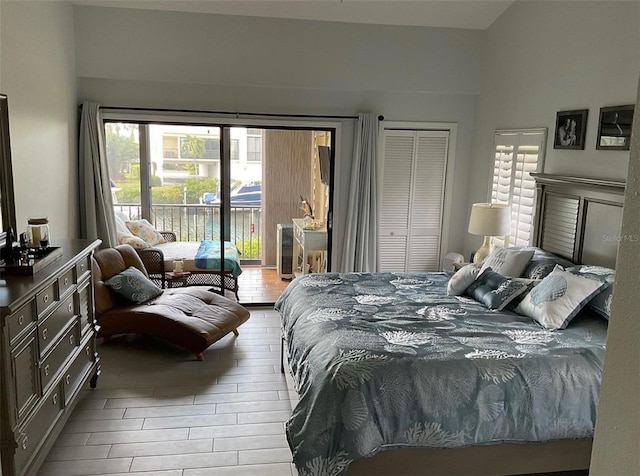 bedroom with access to exterior, a closet, and wood finished floors