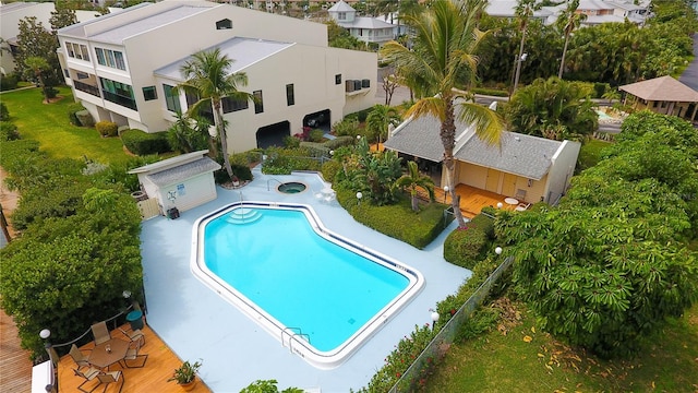 pool featuring a patio area, a community hot tub, and fence