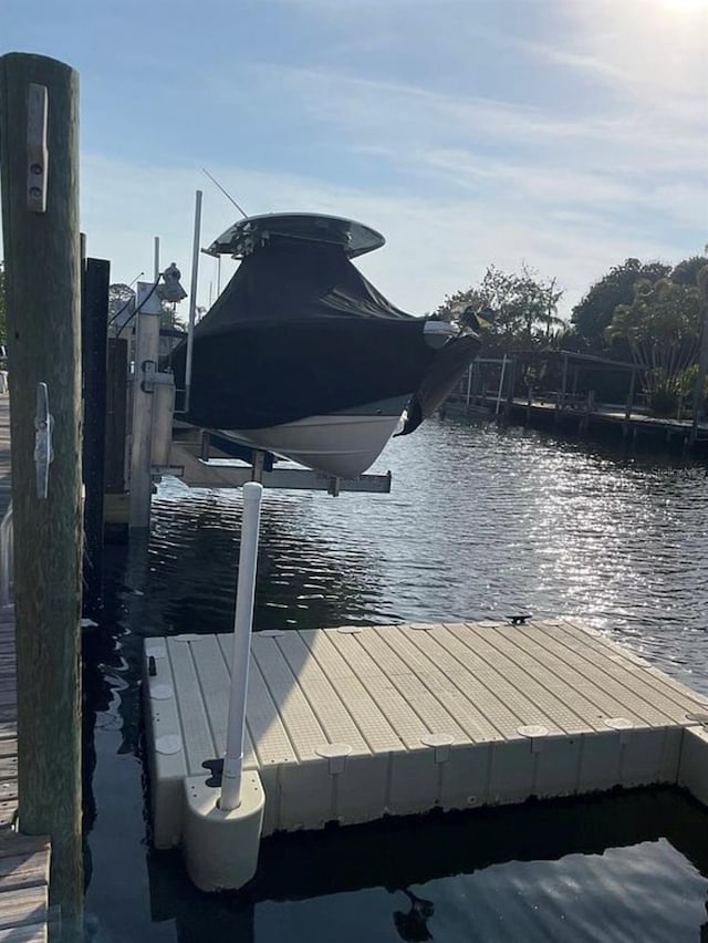 dock area with boat lift and a water view