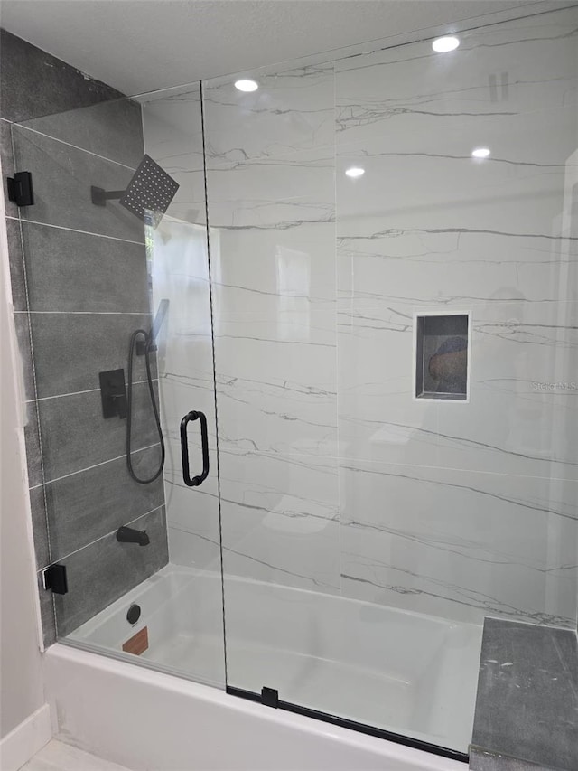 bathroom with combined bath / shower with glass door