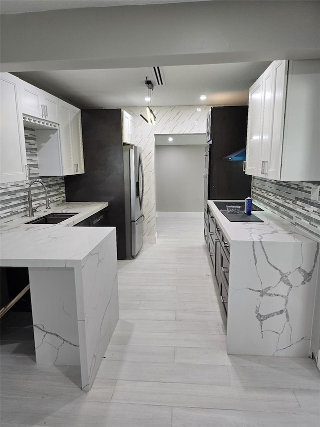 kitchen with white cabinetry, black electric stovetop, light stone counters, and stainless steel refrigerator with ice dispenser