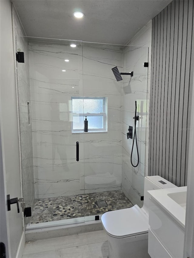 full bath with a marble finish shower, toilet, and vanity