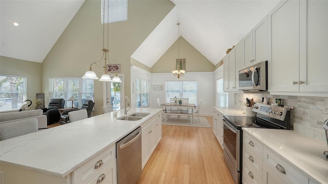 kitchen featuring a sink, light wood-type flooring, appliances with stainless steel finishes, and white cabinetry