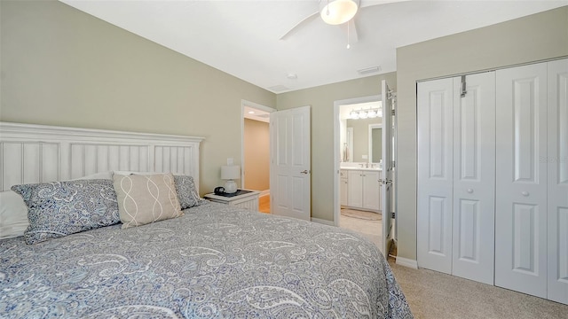 bedroom featuring visible vents, a ceiling fan, ensuite bath, a closet, and light colored carpet