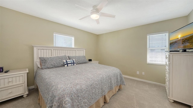 bedroom with light carpet, ceiling fan, and baseboards