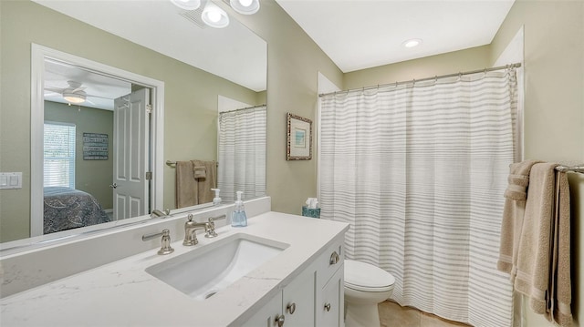 ensuite bathroom featuring connected bathroom, toilet, ceiling fan, and vanity