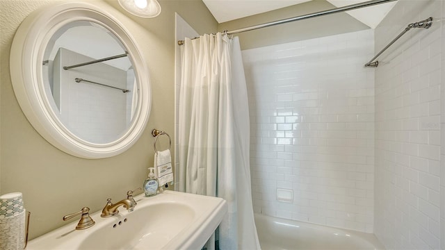 full bath featuring shower / bath combination with curtain and a sink