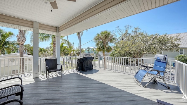 wooden deck featuring a ceiling fan and a grill