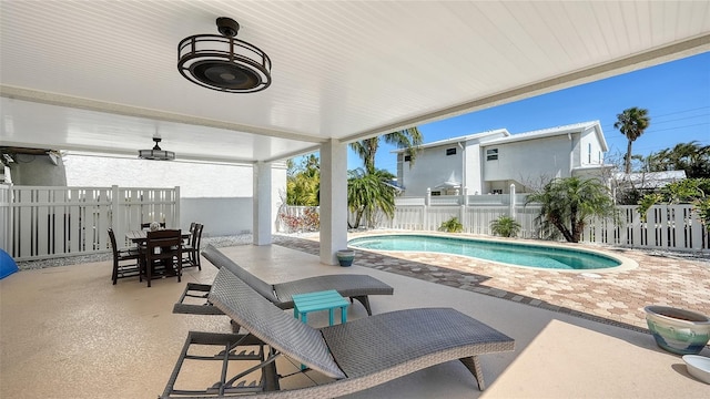 view of swimming pool with a patio area, outdoor dining space, a fenced in pool, and a fenced backyard