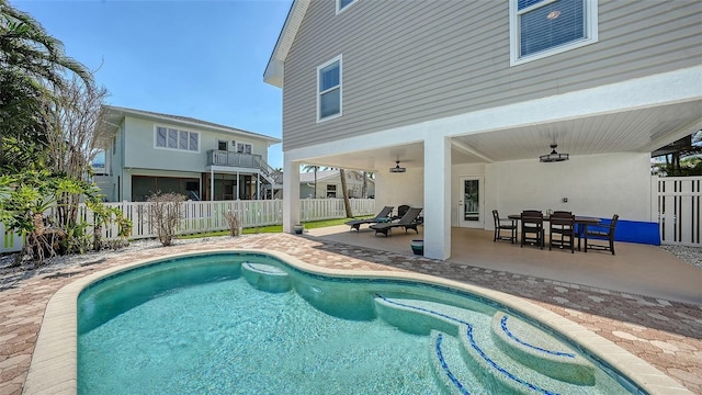 view of swimming pool with a patio area, outdoor dining space, a fenced in pool, and a fenced backyard