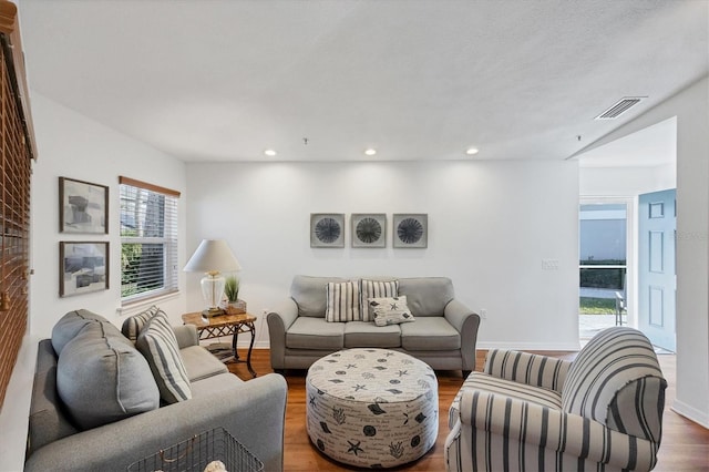 living area featuring recessed lighting, wood finished floors, visible vents, and baseboards