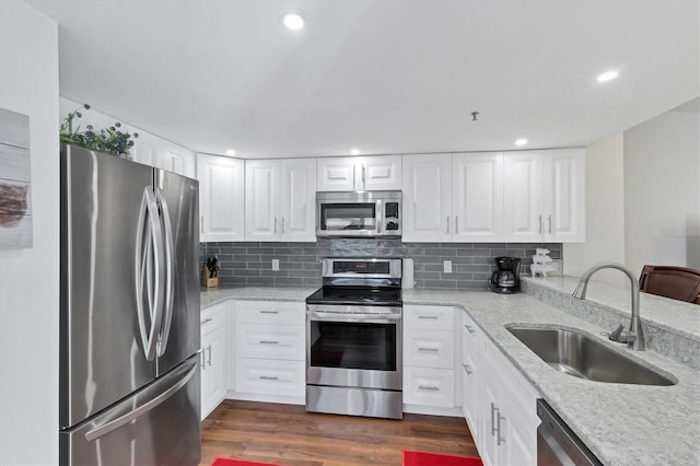 kitchen featuring a sink, tasteful backsplash, appliances with stainless steel finishes, and dark wood-style floors