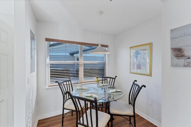 dining space featuring baseboards and dark wood-style flooring