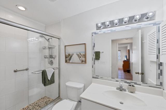 bathroom with vanity, a shower stall, and toilet