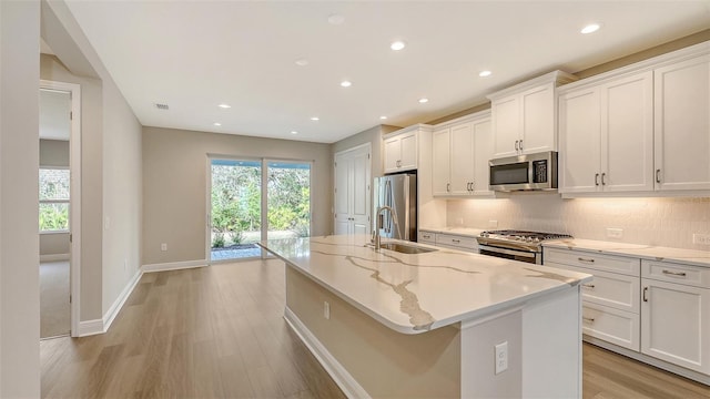 kitchen featuring plenty of natural light, tasteful backsplash, appliances with stainless steel finishes, and white cabinets