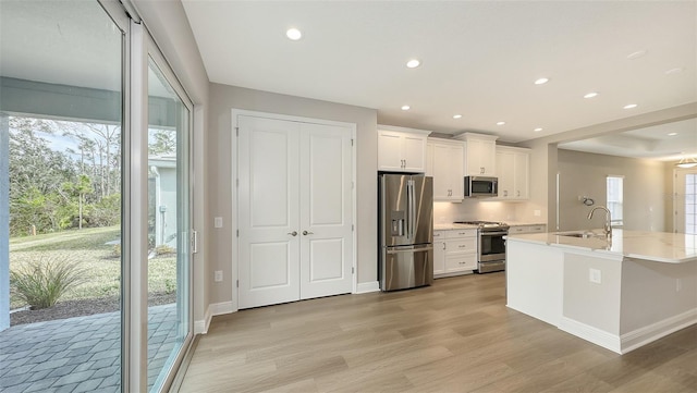 kitchen with recessed lighting, light wood-style floors, appliances with stainless steel finishes, white cabinets, and light countertops