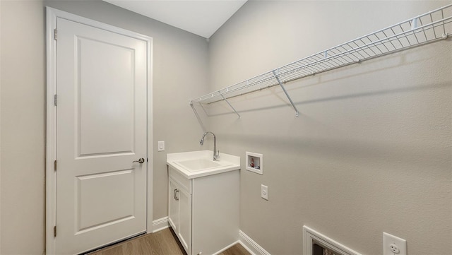 washroom featuring baseboards, dark wood finished floors, washer hookup, cabinet space, and a sink