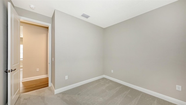 unfurnished bedroom featuring light carpet, visible vents, and baseboards