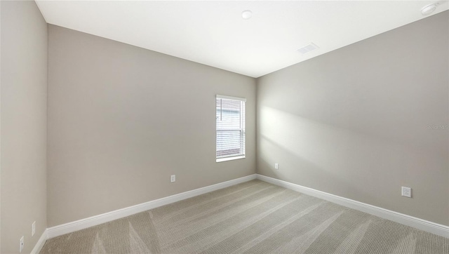 unfurnished room with baseboards, light carpet, and visible vents