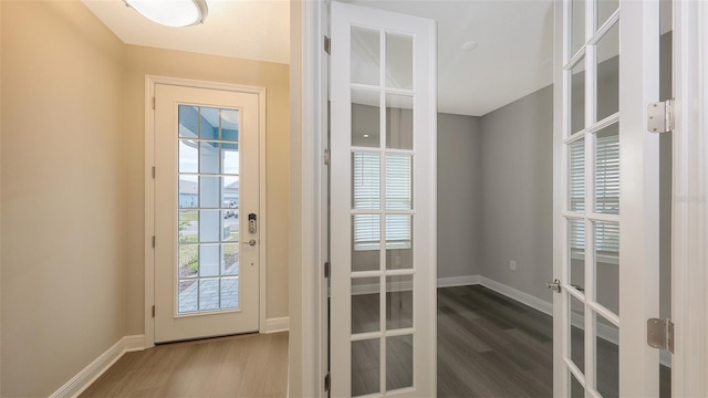 doorway featuring french doors, baseboards, and wood finished floors