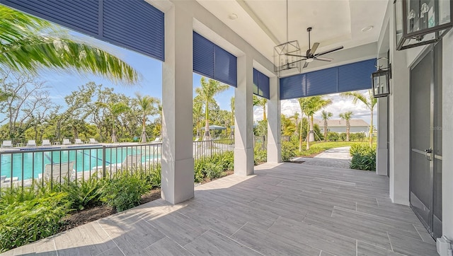 view of patio / terrace featuring a community pool, ceiling fan, and fence