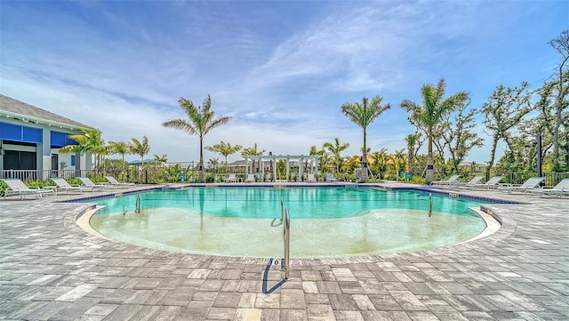 pool with a patio area and fence