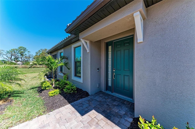 doorway to property featuring stucco siding