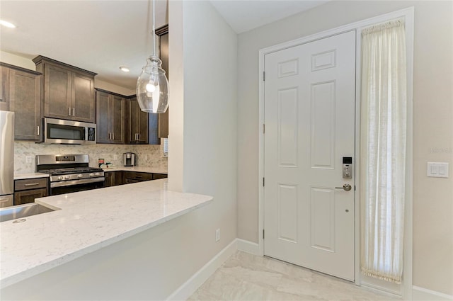 kitchen with marble finish floor, stainless steel appliances, dark brown cabinetry, baseboards, and light stone countertops