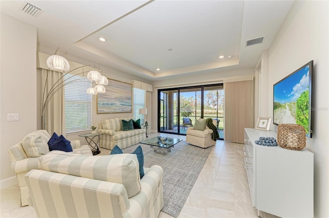 living area featuring recessed lighting, a tray ceiling, and visible vents