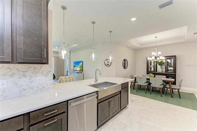 kitchen featuring backsplash, a raised ceiling, stainless steel dishwasher, and dark brown cabinetry