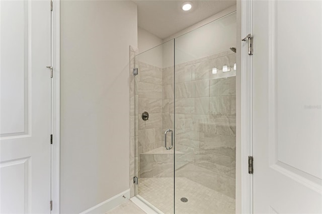 bathroom featuring baseboards and a stall shower