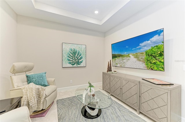 sitting room featuring a raised ceiling, recessed lighting, and baseboards