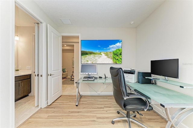 office space featuring visible vents, a textured ceiling, and light wood-type flooring