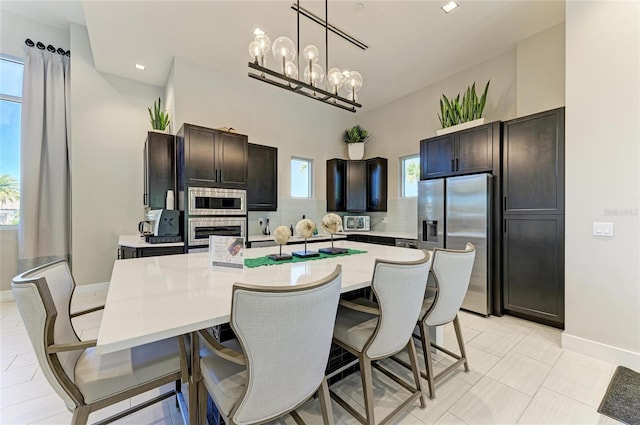 kitchen featuring light countertops, a kitchen breakfast bar, a center island with sink, and stainless steel appliances