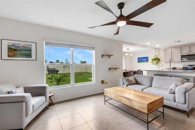 living room with light tile patterned flooring, recessed lighting, baseboards, and a ceiling fan