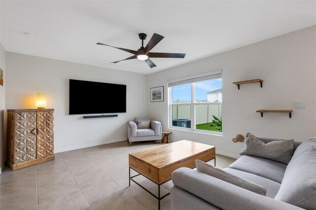 living room with baseboards, ceiling fan, and light tile patterned flooring