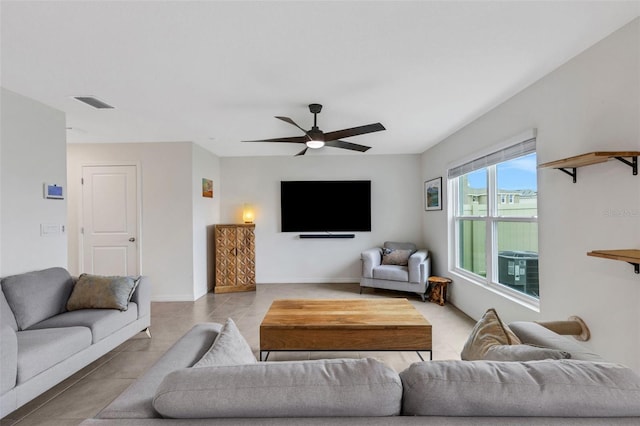 living room featuring light tile patterned floors, a ceiling fan, visible vents, and baseboards